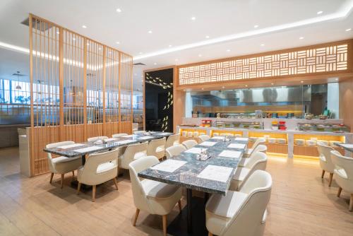 a restaurant with a long table and white chairs at Victoria Hotel Guangzhou Zhujiang New Town - Free shuttle bus during Canton Fair period in Guangzhou