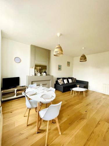 un salon avec une table et des chaises blanches dans l'établissement Le Saint-Louis l Coeur de Ville, à La Rochelle