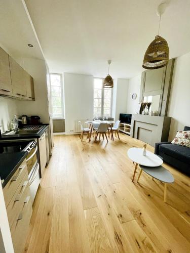 Il comprend un grand salon avec une cuisine et une table. dans l'établissement Le Saint-Louis l Coeur de Ville, à La Rochelle