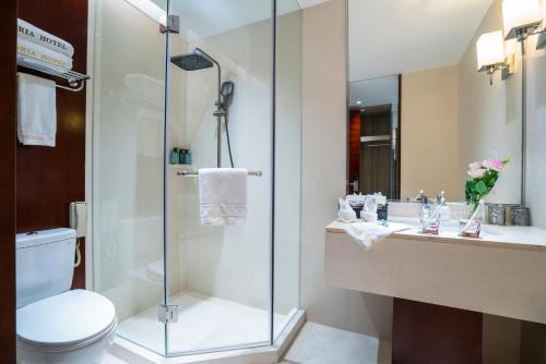 a bathroom with a shower and a toilet and a sink at Victoria Hotel Guangzhou Zhujiang New Town - Free shuttle bus during Canton Fair period in Guangzhou