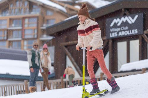 a young girl is on skis in the snow at Hôtel Club mmv Les Arolles **** in Val Thorens