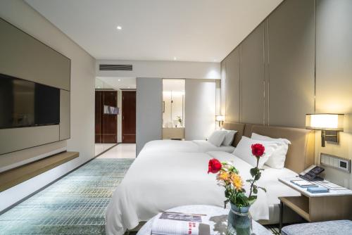 a hotel room with two beds and a tv at Victoria Hotel Guangzhou Zhujiang New Town - Free shuttle bus during Canton Fair period in Guangzhou