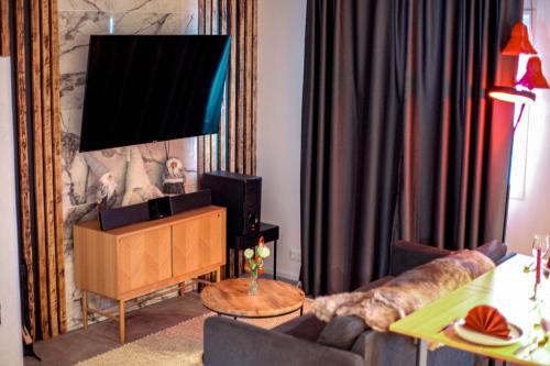 a living room with a couch and a flat screen tv at Arctic Glow Apartment 3 in Ivalo