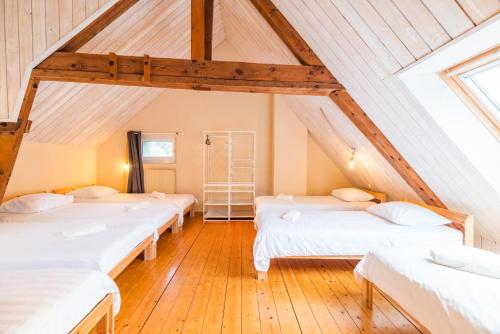 a room with four beds in a attic at Ancien Moulin rénové à neuf pour 20 personnes sur les rives du Trieux in Plésidy