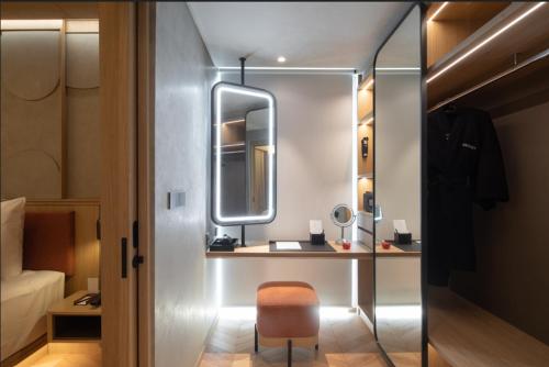 a bathroom with a mirror and a chair in a room at Morrissey Hotel in Jakarta