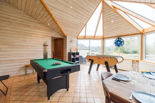 a room with a pool table and a table at Ancien Moulin rénové à neuf pour 20 personnes sur les rives du Trieux in Plésidy