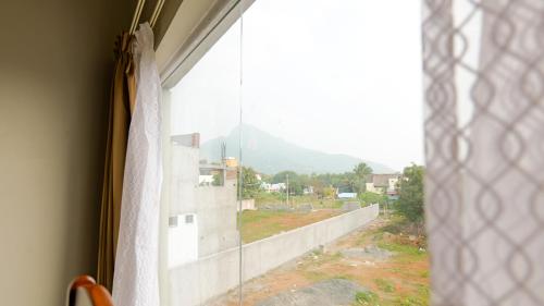 a window with a view of a building at Dwaraka Resorts in Tiruvannāmalai
