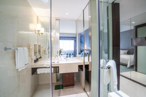 a bathroom with a sink and a mirror at Victoria Hotel Guangzhou Zhujiang New Town - Free shuttle bus during Canton Fair period in Guangzhou