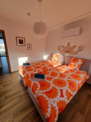 a bedroom with a bed with an orange and white comforter at Cerf, ouvre-moi B&B in Rochefort