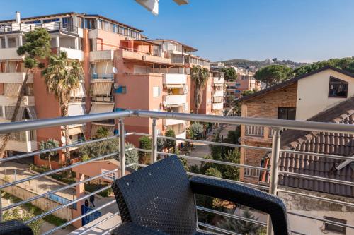 a chair sitting on a balcony with buildings at Golemi Lux Hotel in Golem