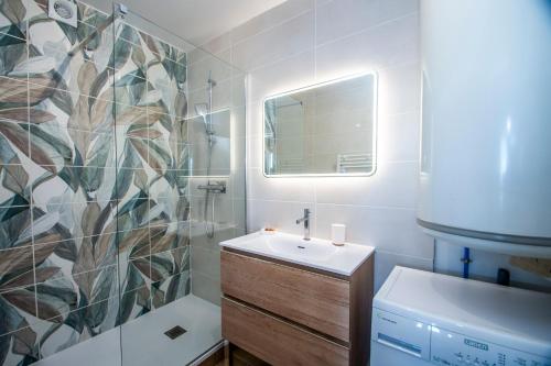 a bathroom with a sink and a shower and a mirror at La Ludette - Pied des pistes à Pla dAdet in Saint-Lary-Soulan