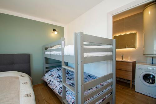 a bedroom with two bunk beds and a washing machine at La Ludette - Pied des pistes à Pla dAdet in Saint-Lary-Soulan