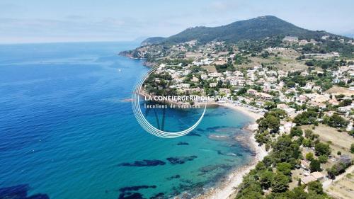 - une vue aérienne sur une plage avec un pont sur l'eau dans l'établissement Studio rénové face à la mer - Port de Carqueiranne, à Carqueiranne