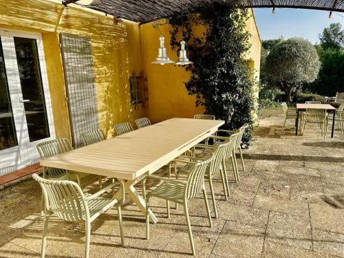 une table et des chaises en bois sur une terrasse dans l'établissement Villa 4 bedrooms for 8 People with Heated Pool 4km from Aix Center, Agarrus Aix, à Aix-en-Provence
