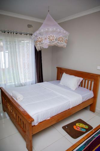 a bedroom with a wooden bed with a chandelier at Stadium View Executive Guest House in Lilongwe