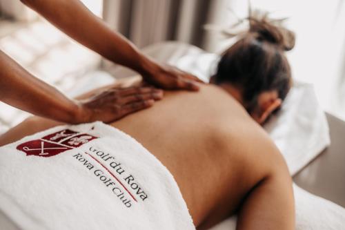 a woman getting a back massage at a spa at Golf du Rova Luxury Hotel in Antananarivo