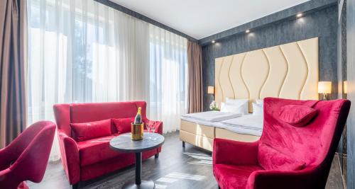 a hotel room with a bed and two chairs at PLAZA Premium Schwerin in Schwerin