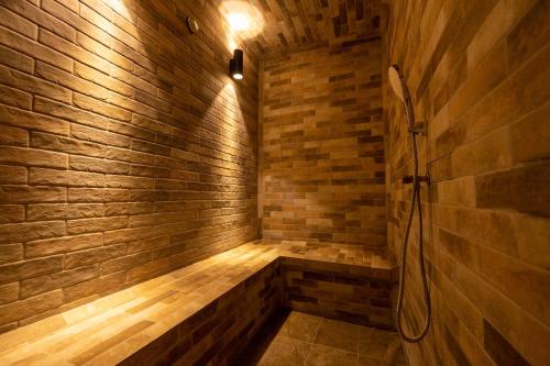 a bathroom with a shower in a brick wall at Golf du Rova Luxury Hotel in Antananarivo