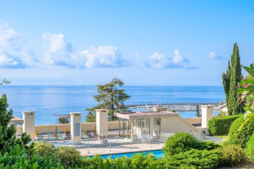 - une vue sur un complexe avec l'océan en arrière-plan dans l'établissement Les Miradors, charmant appartement de 2 chambres en RDC, jardin privatif, piscine, vue mer et parking, à Menton