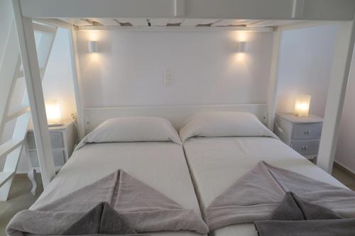 a white bed with two pillows in a bedroom at Logaras' Villas in Logaras