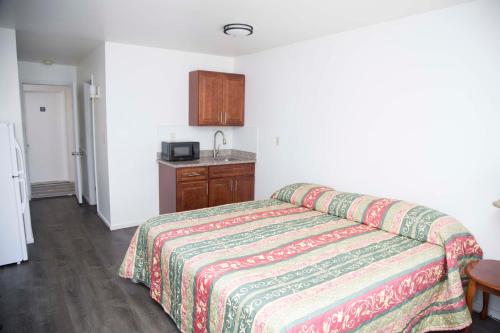 a hotel room with a bed and a kitchen at Lake George Residence LLC in South Glens Falls