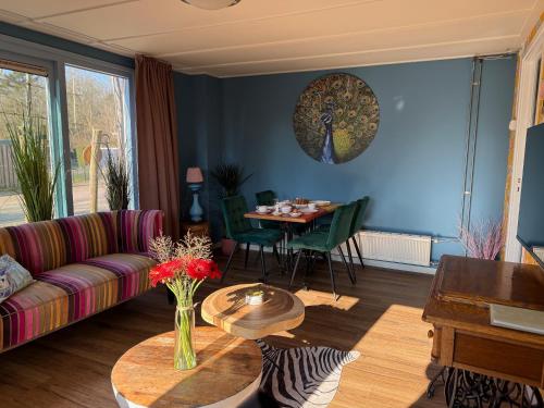 a living room with a couch and a table at Eekhoorn, vakantiehuis met barrelsauna in Voorthuizen