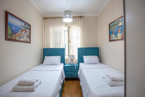 two beds in a small room with blue accents at Montesan Luxury Apartment Beach Front in Sveti Stefan