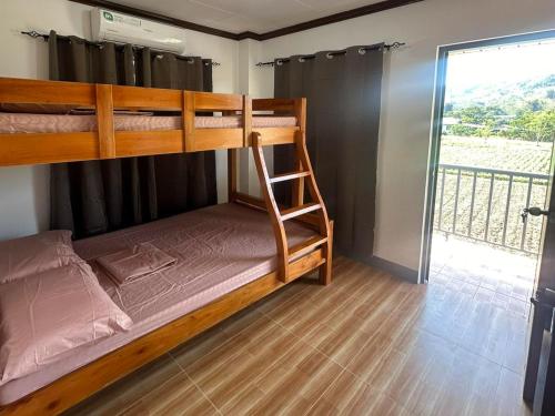 a bedroom with two bunk beds and a balcony at Keps Boarding House in San Fernando