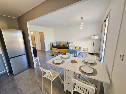 une cuisine et un salon avec une table et des chaises dans l'établissement Bel appartement 1 chambre, WIFI, vue mer, tout à pied, à Saint-Mandrier-sur-Mer
