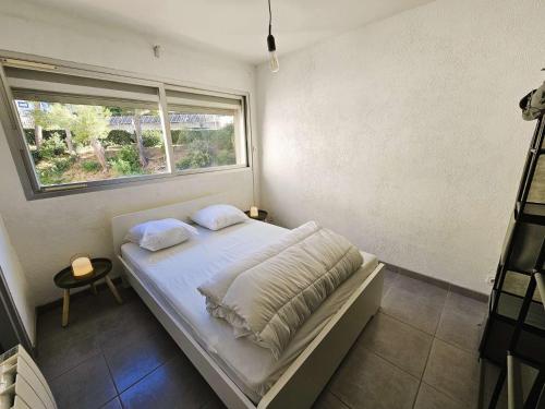 - une petite chambre avec un lit et une fenêtre dans l'établissement Bel appartement 1 chambre, WIFI, vue mer, tout à pied, à Saint-Mandrier-sur-Mer