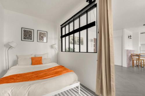 une chambre avec un lit et une grande fenêtre dans l'établissement Le Canal Ocre - Netflix - Parking Couvert, à Toulouse