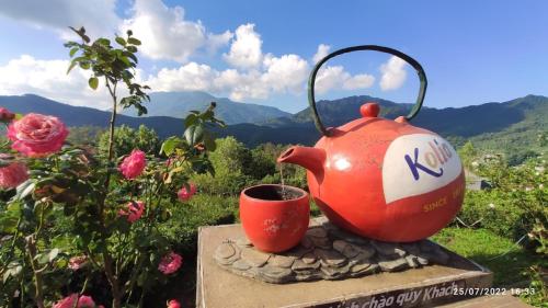 a red tea kettle and a cup on a rock at Kolia Resort in Cao Bằng