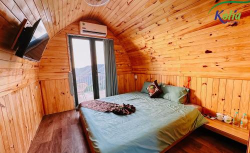 a bedroom with a bed in a wooden cabin at Kolia Resort in Cao Bằng