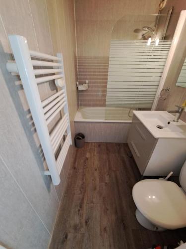 une salle de bain avec toilettes, lavabo et baignoire dans l'établissement Les Iris T2 Station de ski Auris Alpes d'Huez, à Auris
