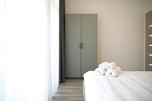 a bedroom with a bed with towels on it at Kintų Perlas Vila keturiems VIII in Kintai