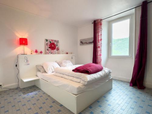 un lit blanc dans une chambre avec une fenêtre dans l'établissement La Pervenche, à Saint-Julien-du-Gua