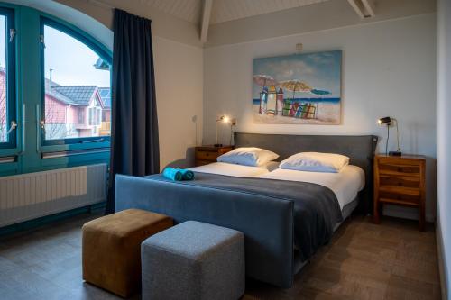 ein Schlafzimmer mit zwei Betten und einem großen Fenster in der Unterkunft Grasse 150 - Kustpark Village Scaldia in Hoofdplaat