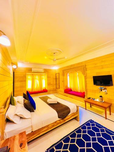 a bedroom with a large bed and a tv at Garh Villa Jaisalmer in Jaisalmer