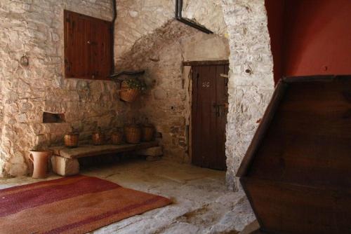 a stone room with a bench and a door at Masia Cal Millàs - Turisme Rural in Castellfullit de Riubregós