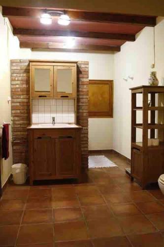 a kitchen with wooden cabinets and a tile floor at Masia Cal Millàs - Turisme Rural in Castellfullit de Riubregós