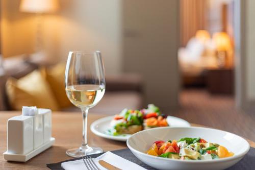 a table with a plate of food and a glass of wine at Maidan Palace Hotel in Kyiv