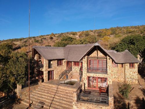 a large stone house with a black roof at Sable Mountain in Hekpoort