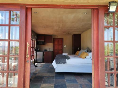 a bedroom with a bed in a room with glass doors at Sable Mountain in Hekpoort
