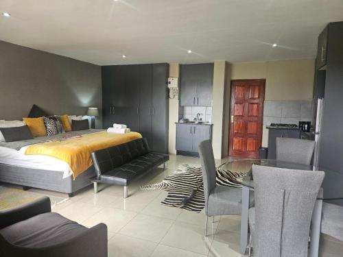 a bedroom with a bed and a table and chairs at Sable Mountain in Hekpoort