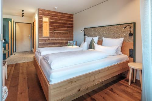 a bedroom with a large bed with a wooden headboard at Hotel Oberstdorf in Oberstdorf
