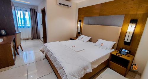 a bedroom with a large bed and a telephone at Hotel Occazia Lubumbashi in Lubumbashi