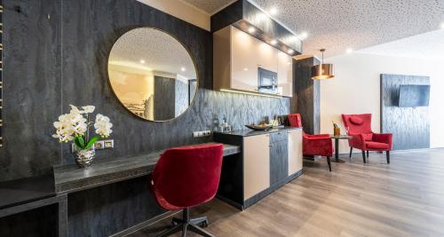 a living room with a mirror and red chairs at PLAZA Premium Schwerin in Schwerin