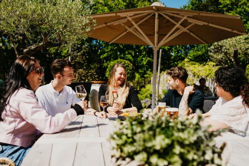 a group of people sitting around a table with wine glasses at Hotel de Zeeuwse Stromen - Duinpark in Renesse