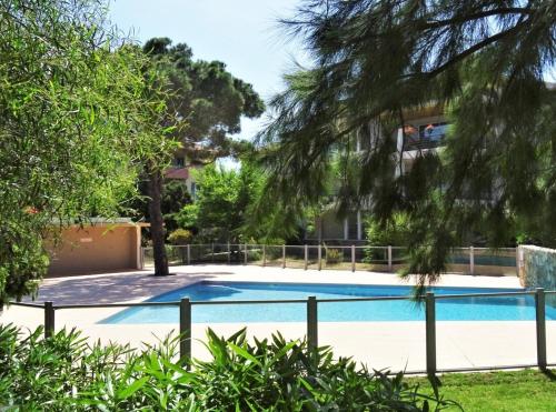 une piscine devant un immeuble avec des arbres dans l'établissement Appartement Azzurra, à Calvi