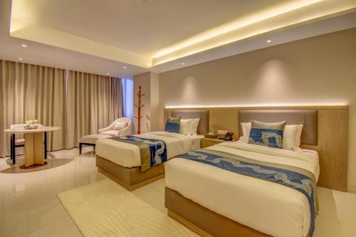 a hotel room with two beds and a chair at THE SSK Solitaire , Boutique Hotel and SPA in Nashik